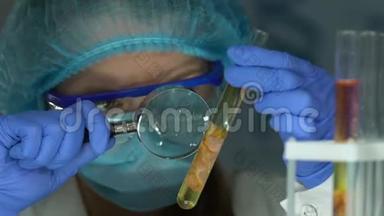 女研究员用放大镜检查试管中的肉样本